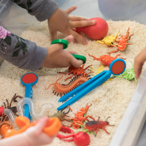 toddler hands playing with toys in a sandbox
