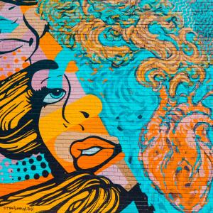 brick wall with bright pop art depiction of a woman